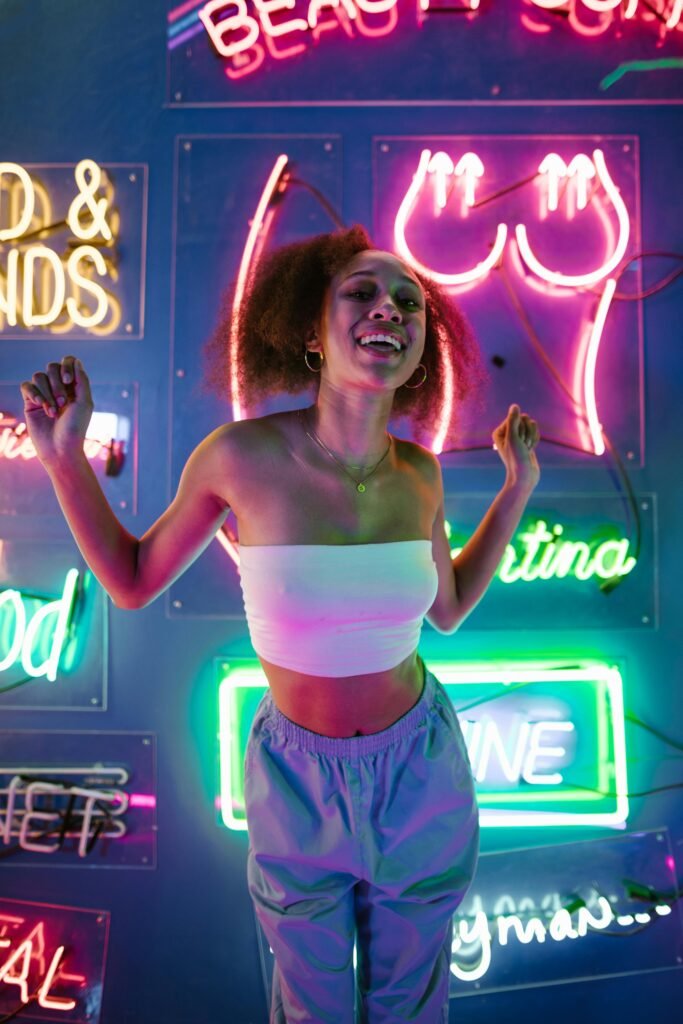 pexels-photo-8112620-8112620 A young woman enjoying nightlife surrounded by colorful neon lights in a club setting.